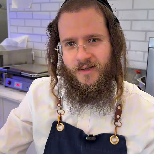 Behind the counter at MilkPod — white tiles, fresh kitchen, navy aprons